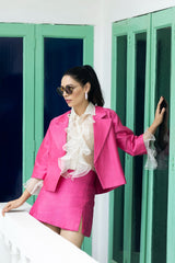 White ruffled top with pink jacket and pink slit shorts